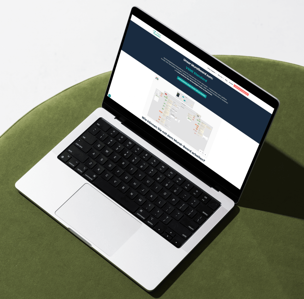 Ein Laptop auf einem Grünen Kissen mit der Internetseite zum VSME Mural Board Freebie.