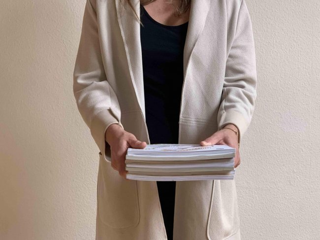 Person hält mehrere Berichten der Hand vor sich zur Visualisierung von Nachhaltigkeitsberichten